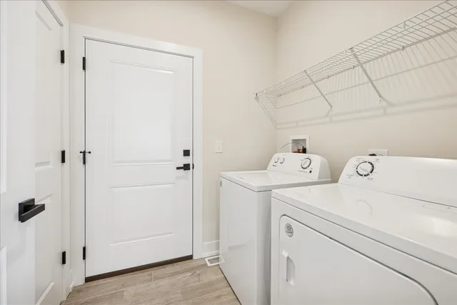 a view of storage and utility room with dryer and washer