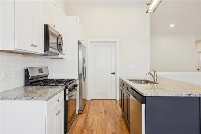 a kitchen with stainless steel appliances granite countertop a sink stove and refrigerator