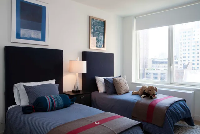 a bedroom with two beds and a window