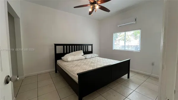 a room with a bed and a chandelier fan