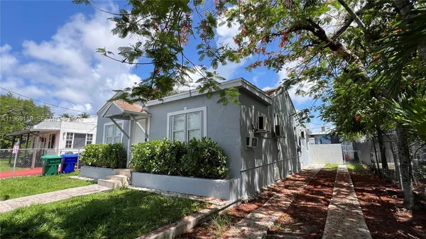 a view of a house with a tree in front of it