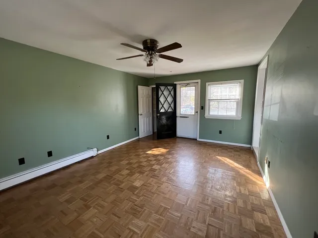 a view of an empty room with window and cabinet