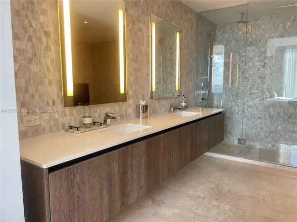 a bathroom with double sink and a mirror