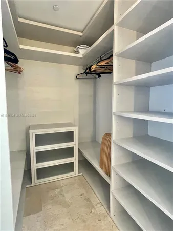 a view of walk in closet with empty racks