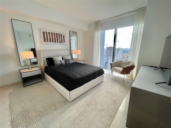 a spacious bedroom with a bed and a large window