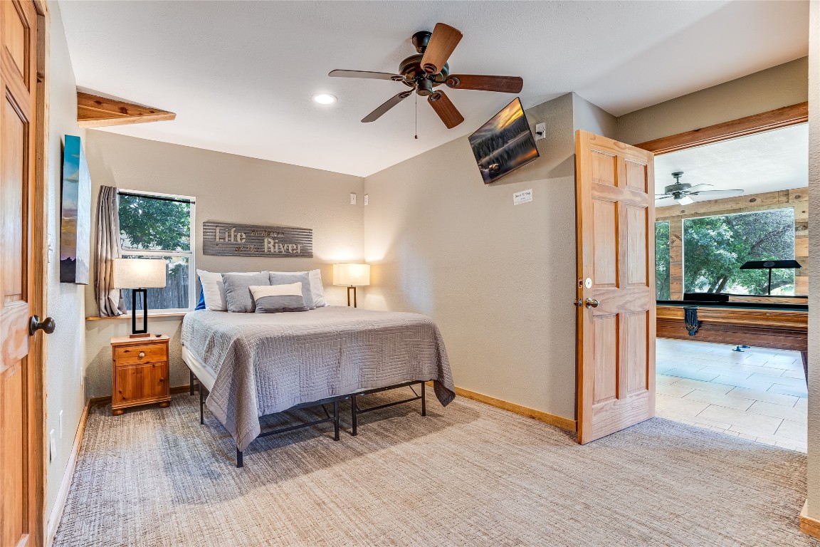 2308 Flite Acres Road Wimberley, TX 78676 - Photo 20 of 35 a bedroom with a bed and a chandelier