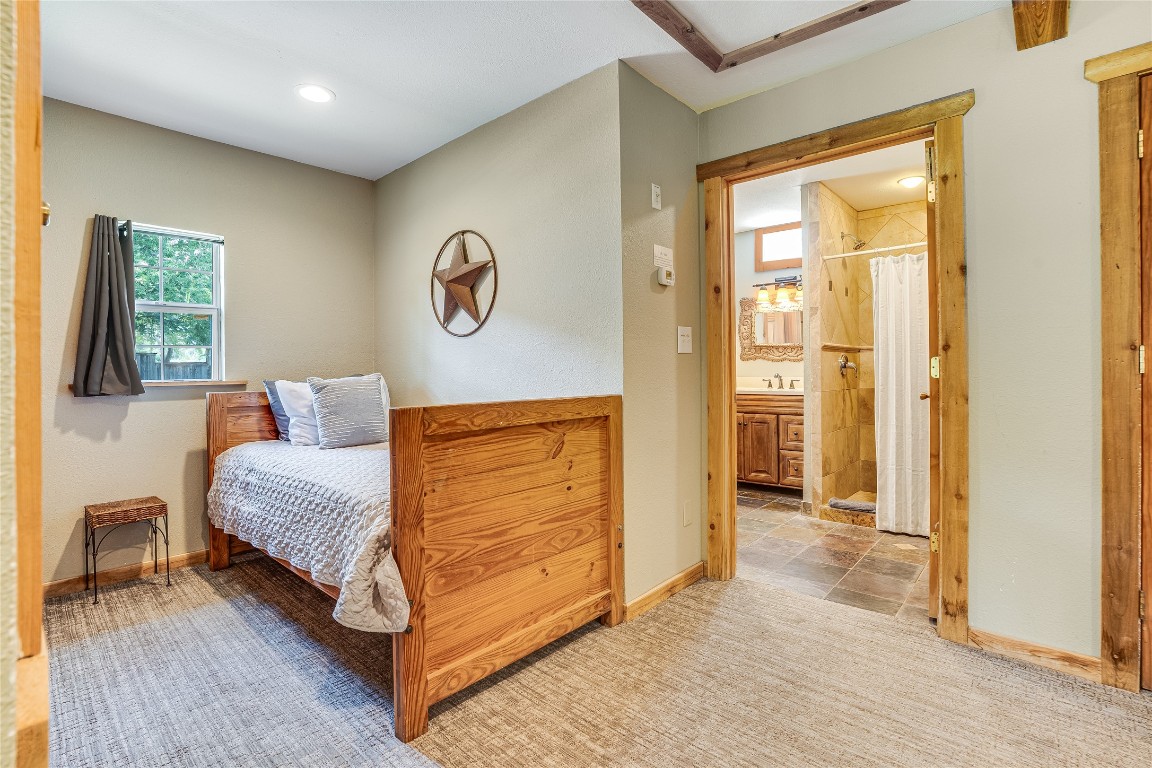 2308 Flite Acres Road Wimberley, TX 78676 - Photo 21 of 35 a spacious bedroom with a bed and a table