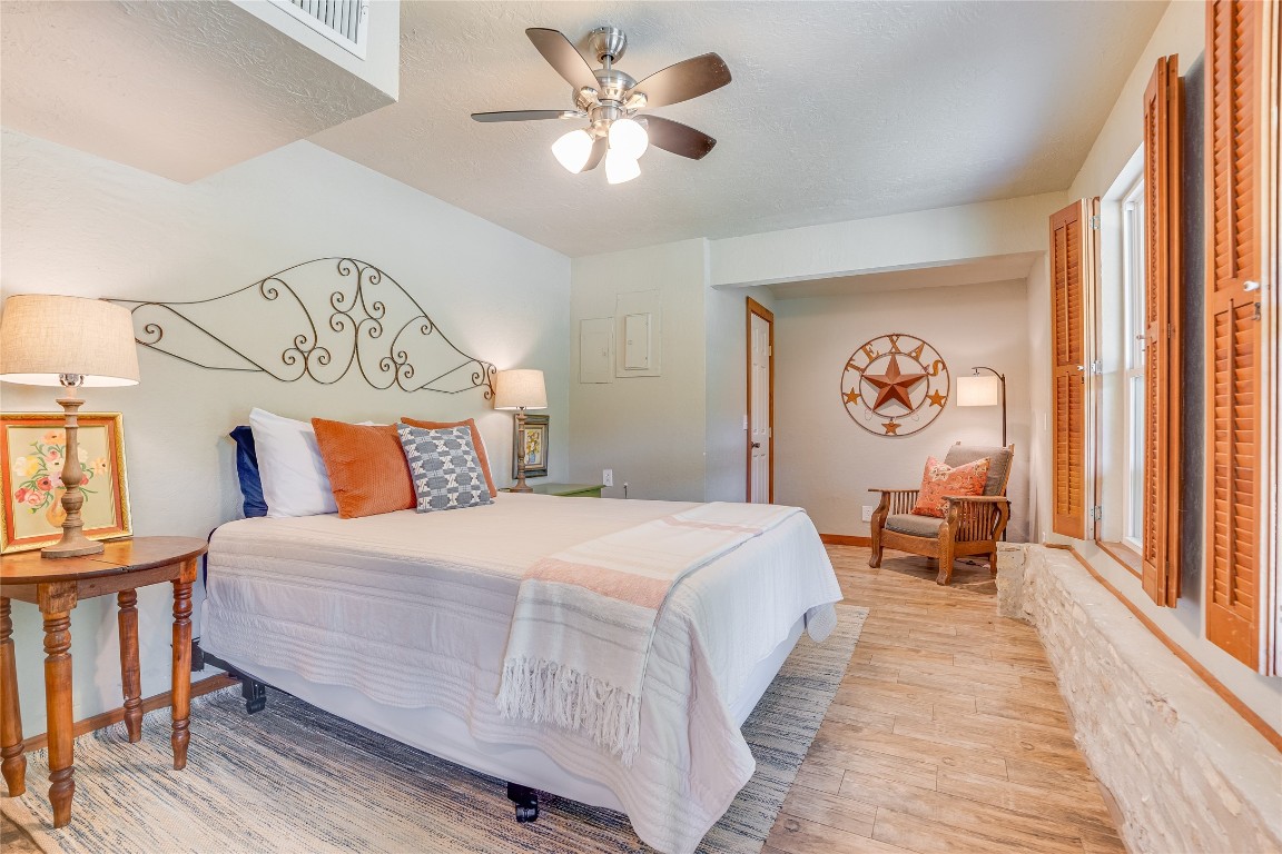 2308 Flite Acres Road Wimberley, TX 78676 - Photo 23 of 35 a bedroom with a bed and a chandelier