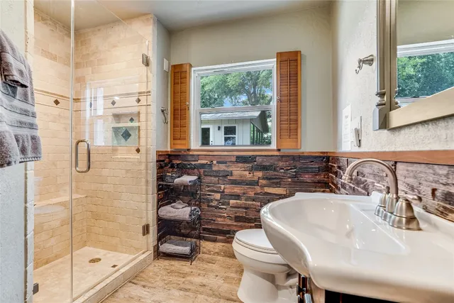 a bathroom with a sink a toilet and shower