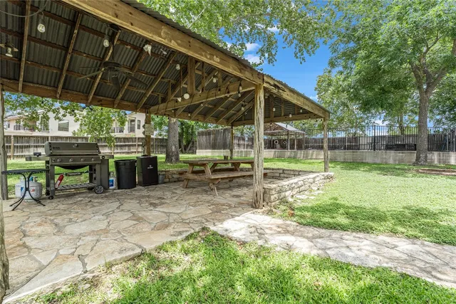 a view of a chair and table in backyard of the house