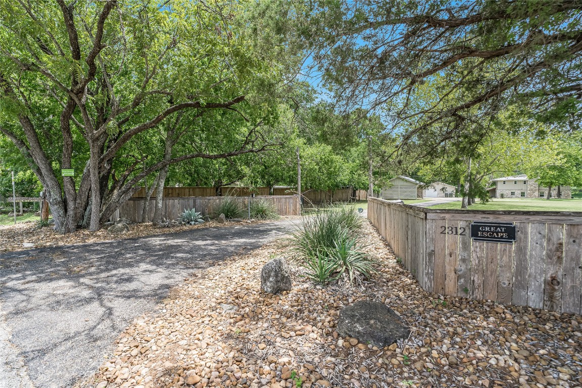 2308 Flite Acres Road Wimberley, TX 78676 - Photo 3 of 35 a view of a backyard with plants and large trees