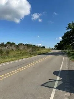 a view of a lake with a yard and mountain in the back