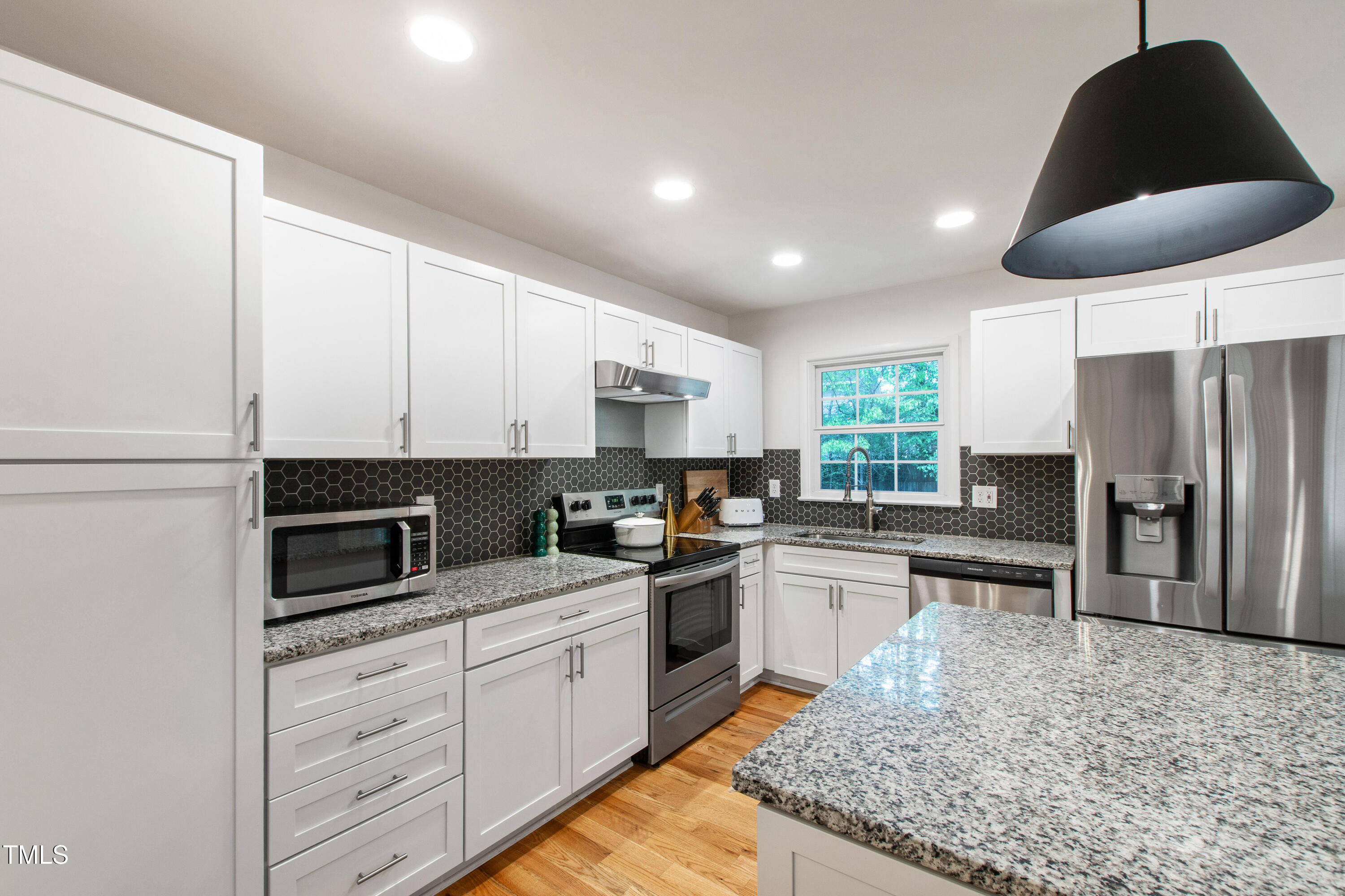 7409 Fiesta Way Raleigh, NC 27615 - Photo 10 of 40 a kitchen with stainless steel appliances granite countertop a sink stove refrigerator and cabinets