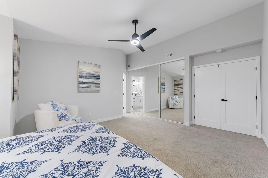460 Compass Road Oceanside, CA 92054 - Photo 25 of 45 a bedroom with a large bed and a chandelier