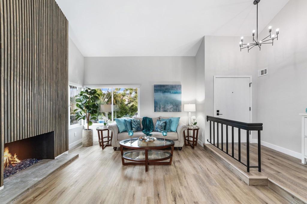 460 Compass Road Oceanside, CA 92054 - Photo 8 of 45 a living room with furniture a fireplace and a floor to ceiling window