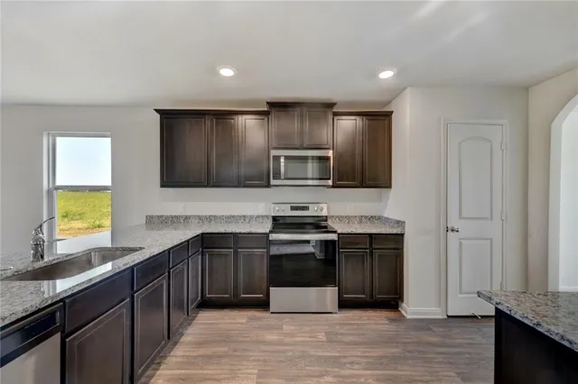a kitchen with stainless steel appliances granite countertop a stove and a sink