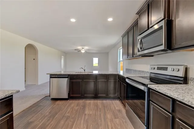 a kitchen with stainless steel appliances granite countertop a sink and a stove top oven