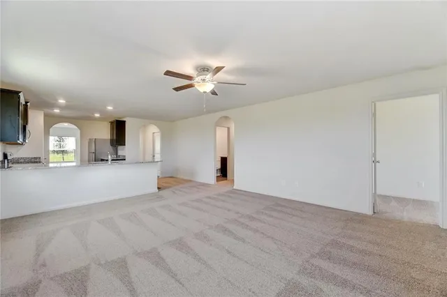 a view of an empty room with a kitchen