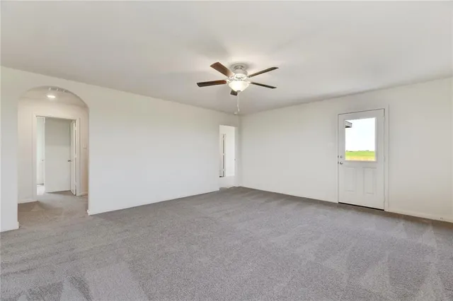 an empty room with a empty space and a ceiling fan