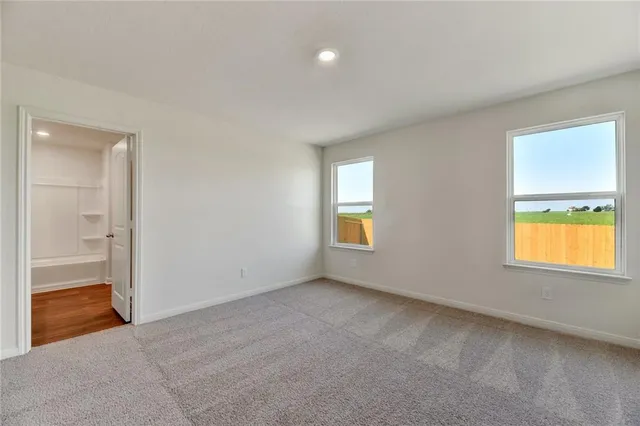 an empty room with windows and mirror