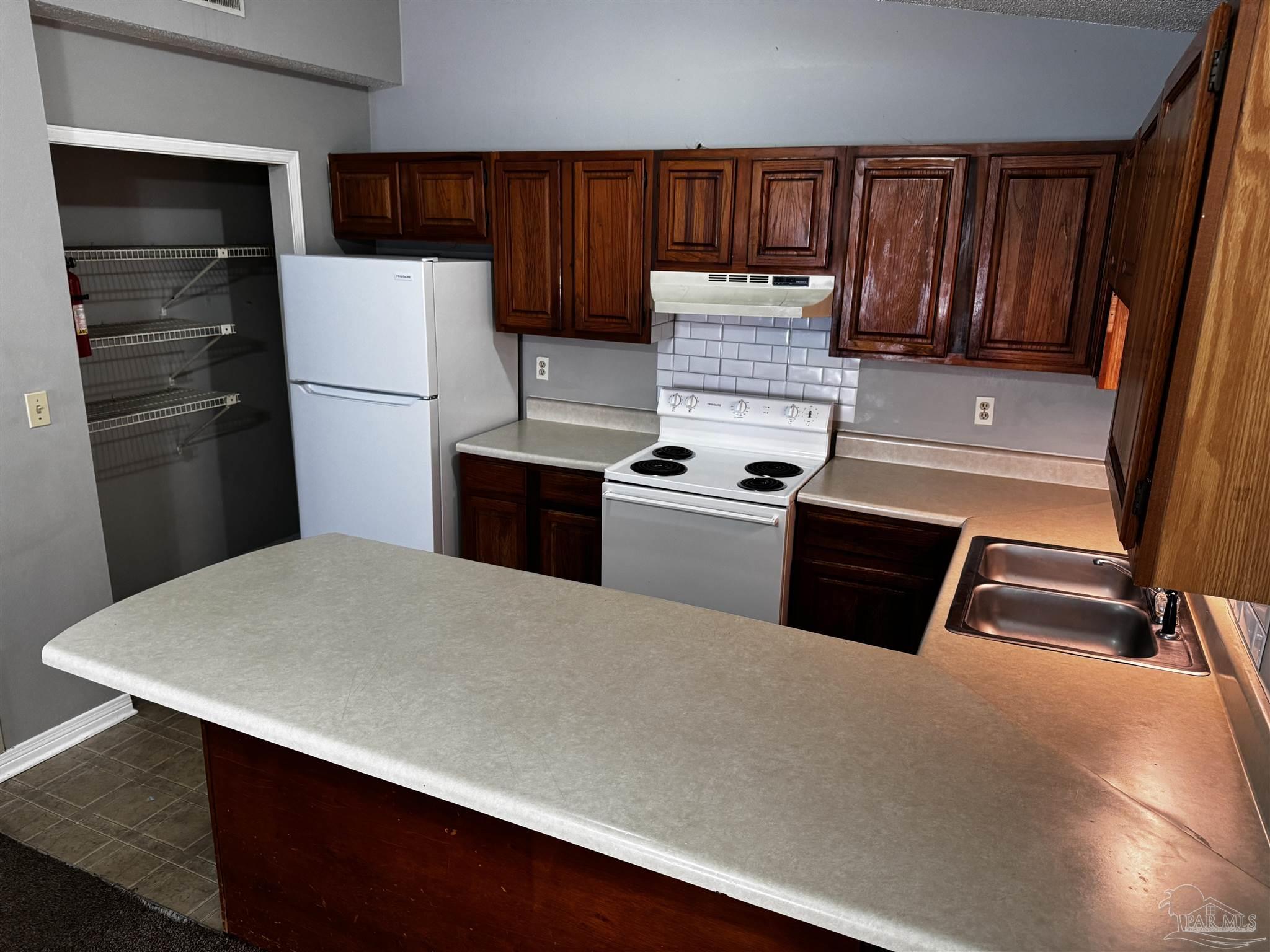 8210 Kipling Street, Unit B Pensacola, FL 32514 - Photo 7 of 17 a kitchen with a refrigerator a stove and a sink