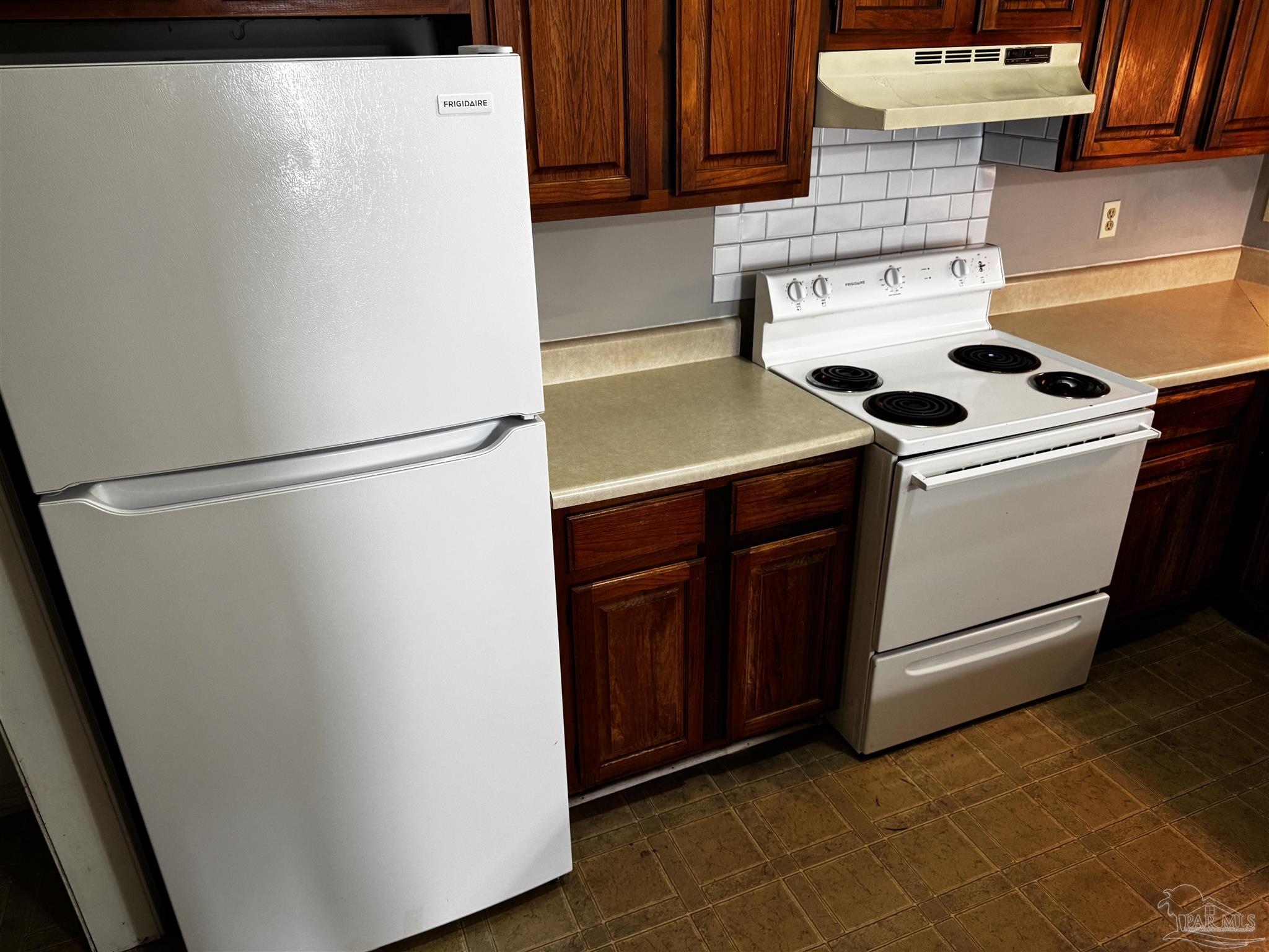 8210 Kipling Street, Unit B Pensacola, FL 32514 - Photo 8 of 17 a white refrigerator freezer and a stove sitting inside of a kitchen