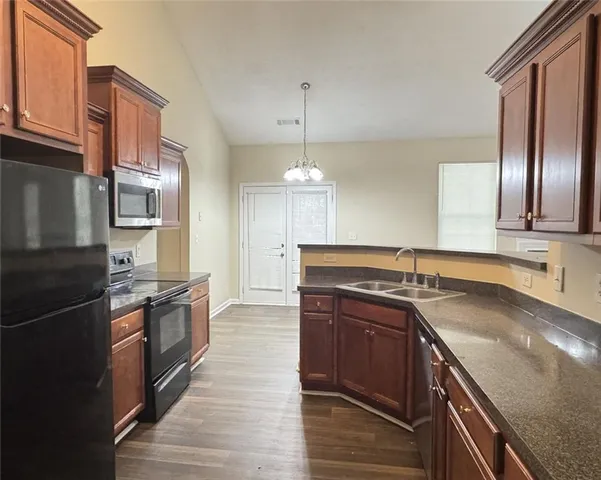 a kitchen with granite countertop stainless steel appliances and wooden cabinets