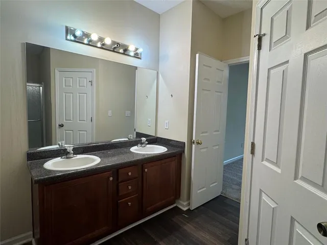 a bathroom with a granite countertop sink a large mirror and a shower