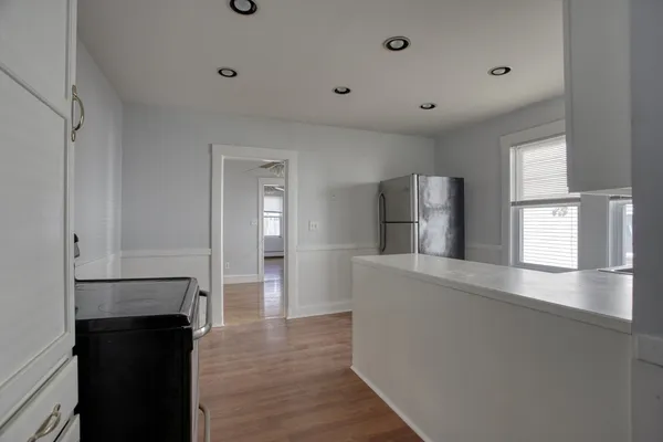 a view of a kitchen with a refrigerator a microwave and a sink