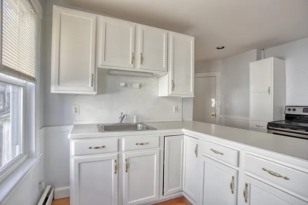 a kitchen with white cabinets and white appliances