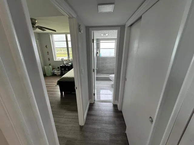 a view of a hallway with a livingroom and furniture