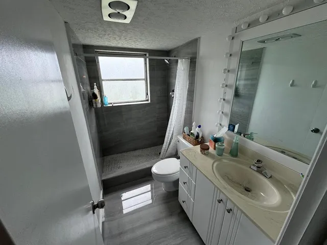 a bathroom with a sink a toilet and shower