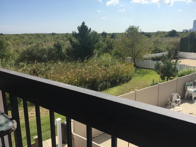 a view of balcony with wooden floor and fence