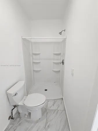 a bathroom with a toilet and a shower