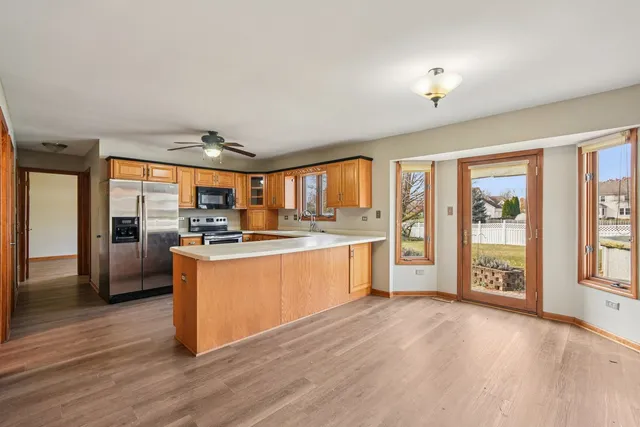 a large kitchen with a large window and wooden floor