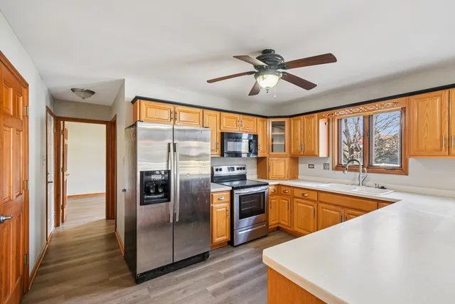 a large kitchen with stainless steel appliances granite countertop a refrigerator a sink and a stove