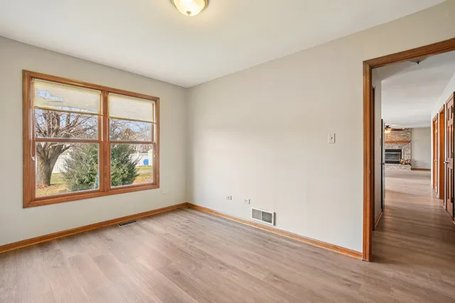 an empty room with wooden floor and a window