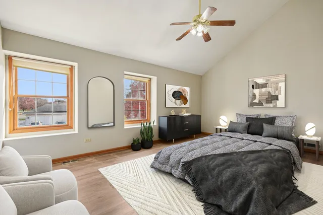 a spacious bedroom with a bed couches and window