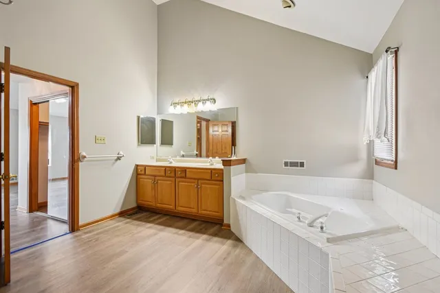 a bathroom with a tub sink and mirror