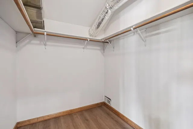 a view of walk in closet with empty racks