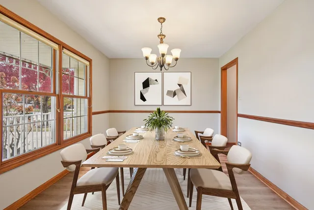 a view of a dining room with furniture a chandelier and wooden floor