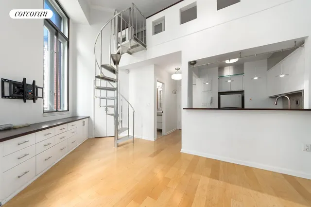 a view of a hallway with granite countertop a couch and white cabinets