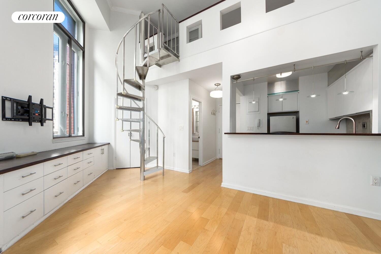 176 West 86th Street, Unit 5B Manhattan, NY 10024 - Photo 2 of 10 a view of a hallway with granite countertop a couch and white cabinets
