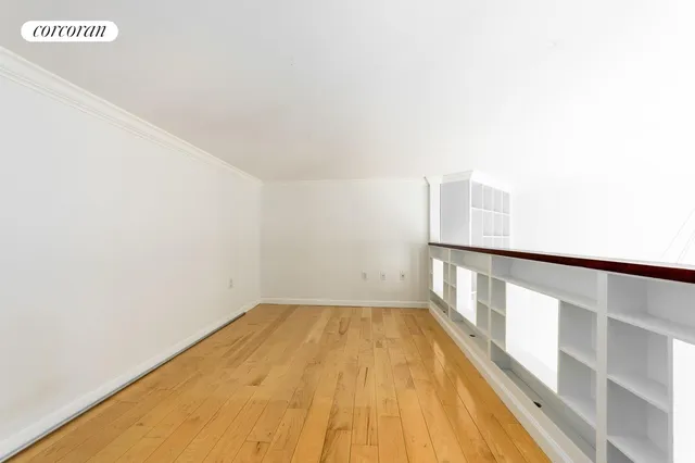 a view of a room with wooden floor and a window