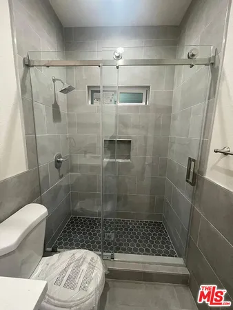 a bathroom with a shower a toilet and a sink
