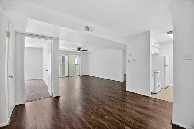 a view of a hallway with wooden floor and closet