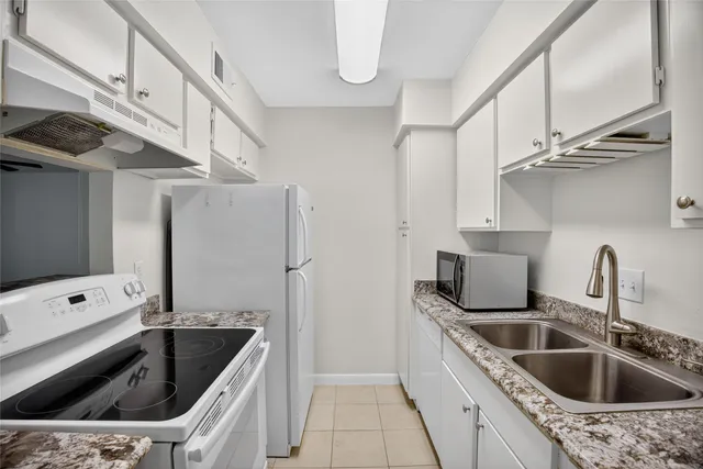 a kitchen with stainless steel appliances kitchen island a stove a refrigerator and a cabinets