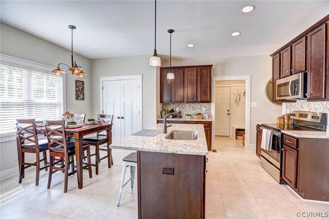 7213 Appelman Road Chesterfield, VA 23832 - Photo 11 of 18 a kitchen with stainless steel appliances granite countertop a stove top oven a sink dishwasher a dining table and chairs with wooden floor