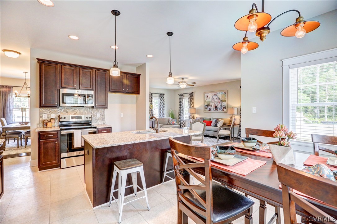 7213 Appelman Road Chesterfield, VA 23832 - Photo 17 of 18 a kitchen with stainless steel appliances granite countertop a stove a sink dishwasher a dining table and chairs with wooden floor