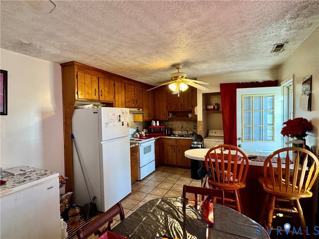 13531 Raynor Road Ivor, VA 23866 - Photo 8 of 16 a kitchen with granite countertop a refrigerator a stove a dining table and chairs with wooden floor
